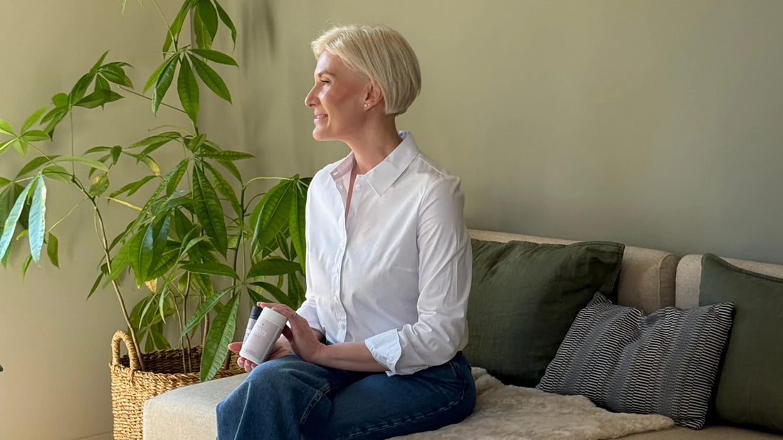Woman looking into the distance, holding HerVibe supplements